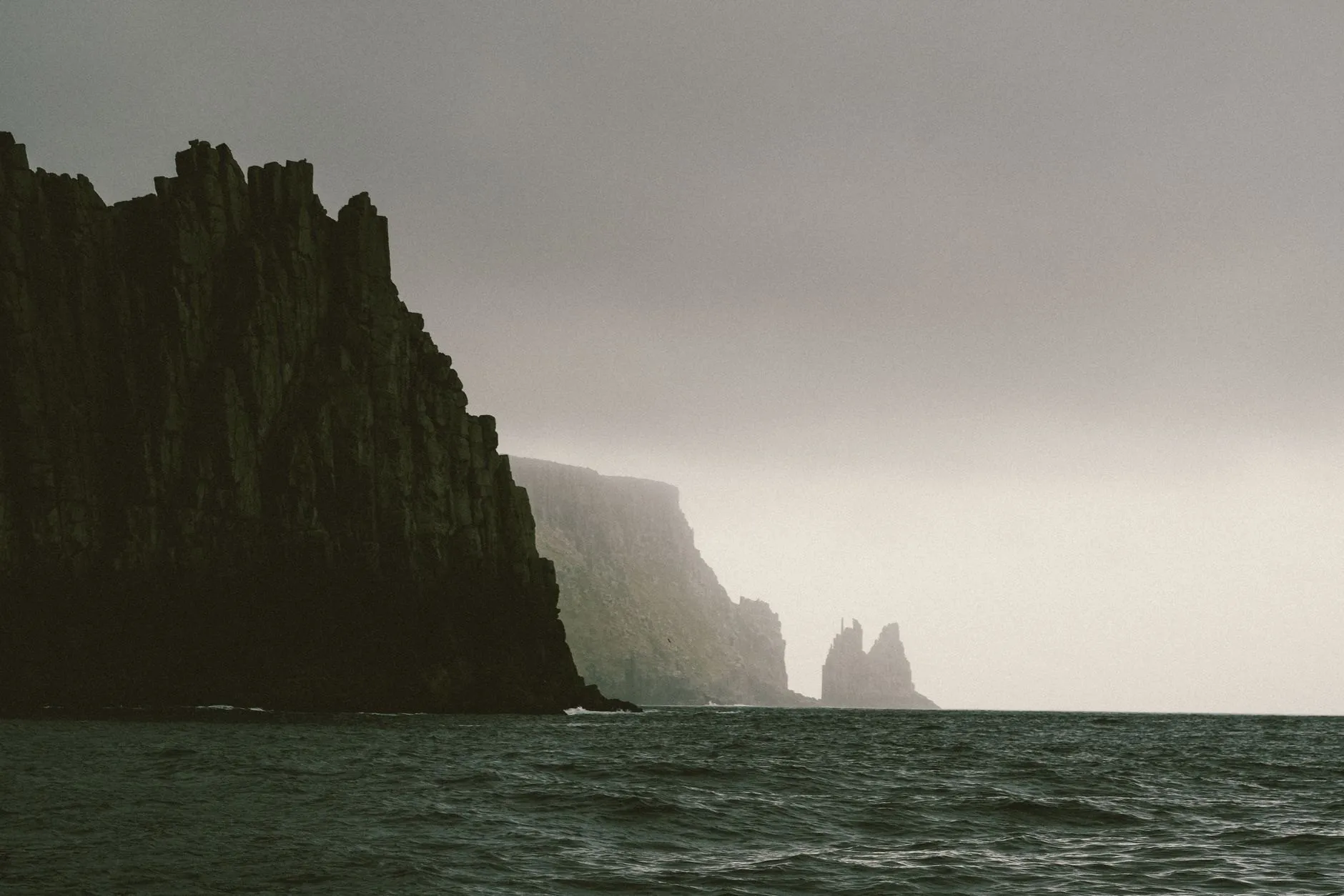 Sea cliffs fading into mist