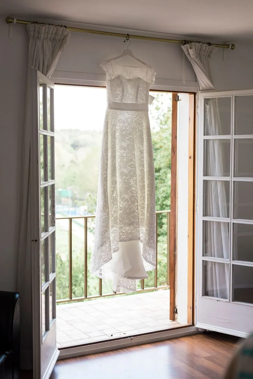 A lace dress hanging in an open balcony doorway