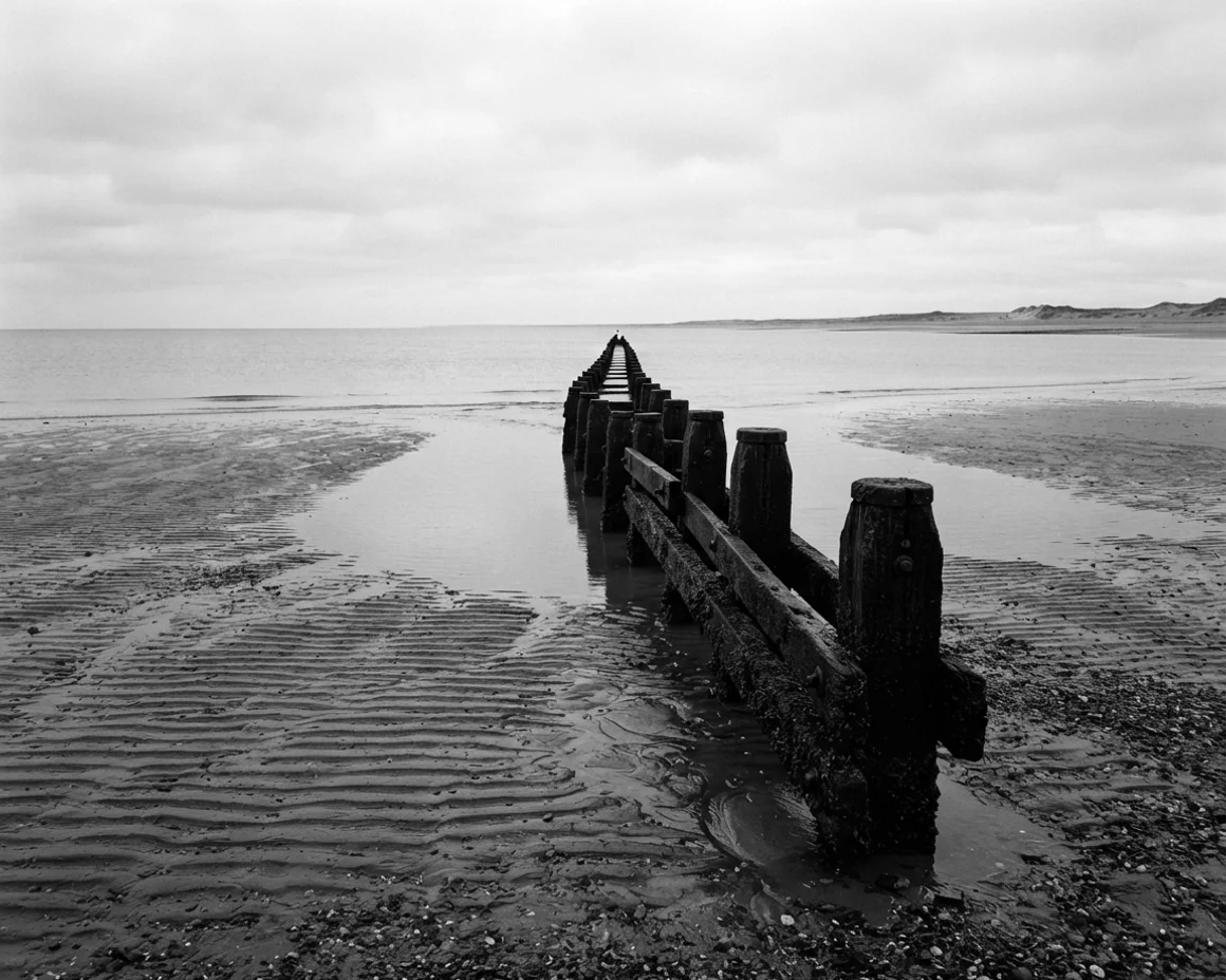 The same photograph of the groynes, printed and fixed but never toned, carrying no colour at any density.
